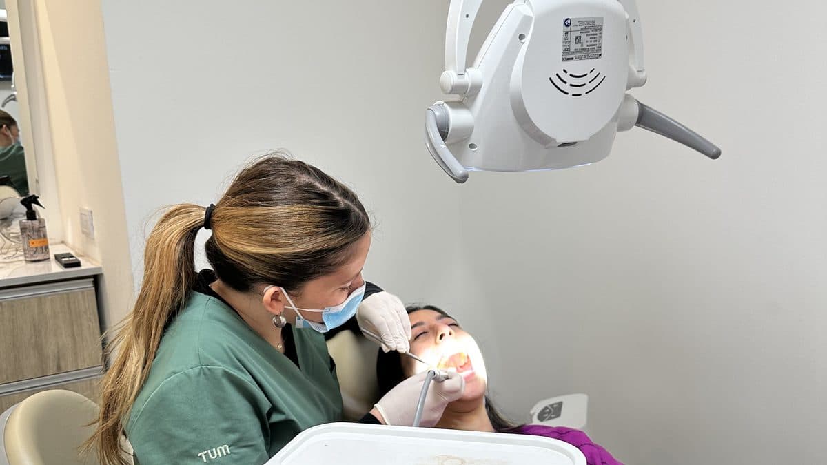 Odontóloga revisando la dentadura de una paciente durante un control de rutina.